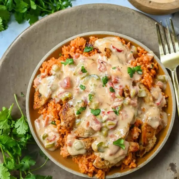 This Queso Smothered Chicken is a comforting, flavor-packed meal that makes everyone at the table ask for seconds — Pollo con Queso is it. This dish brings together juicy sautéed chicken, homemade Spanish rice, and a rich, creamy queso sauce made from scratch. A hearty, cheesy, restaurant-style dish you can make right at home — and better than takeout.
