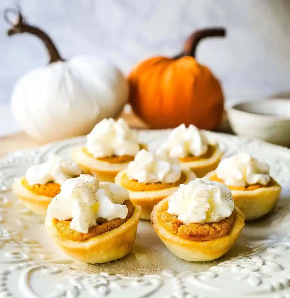 Mini Pumpkin Pie Bites. The best bite-size mini pumpkin pies perfect for entertaining during the holiday season. Creamy pumpkin pie filling in buttery pie crust cups topped with fresh whipped cream. www.modernhoney.com #pumpkinpie #pumpkinpiebites #minipumpkinpies