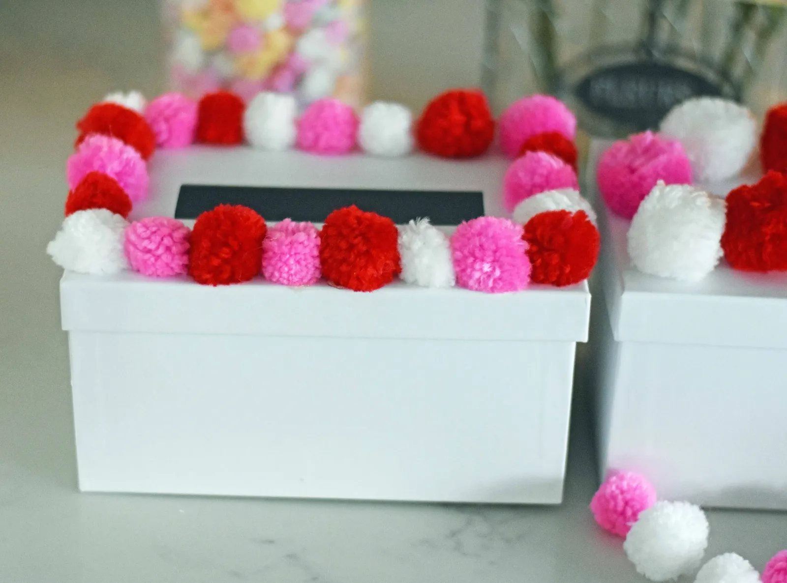 How to decorate Valentine's Day boxes with pom poms. Pom Poms Valentine's Day boxes. Easy Valentine's Day boxes for school. Valentine's Day decorating ideas. www.modernhoney.com