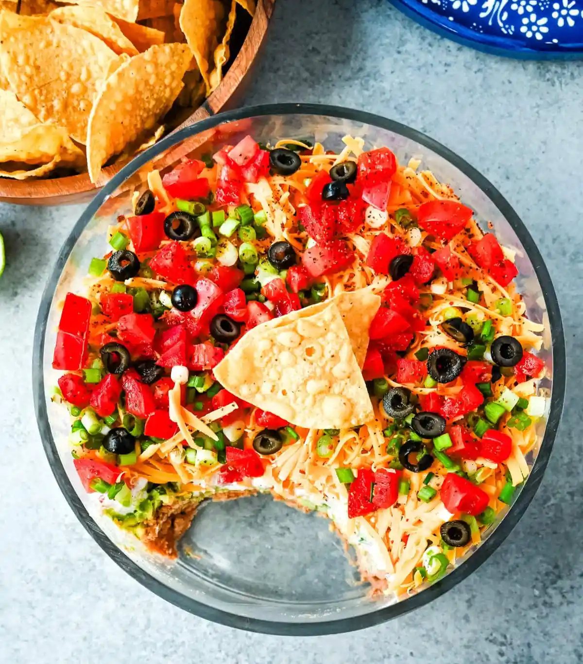 Seven-layer dip is a colorful, Tex-Mex-inspired appetizer featuring layers of refried beans, guacamole, seasoned sour cream, salsa, shredded cheese, fresh tomatoes, and sliced black olives. It’s popular because it’s easy to make, makes a stunning presentation, is delicious, and always a hit at parties or game-day gatherings. Whether you’re hosting a Super Bowl watch party or a casual family get-together, a classic 7 layer dip is guaranteed to impress.