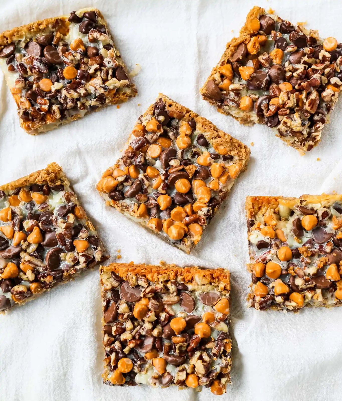 7-Layer Magic Bars. The famous dessert bars made with a graham cracker crust, sweetened flaked coconut, chocolate chips, butterscotch chips, nuts, all drizzled with sweetened condensed milk. The perfect dessert bar recipe! www.modernhoney.com #7layerbars #magicbars #magiccookiebars #sevenlayerbars