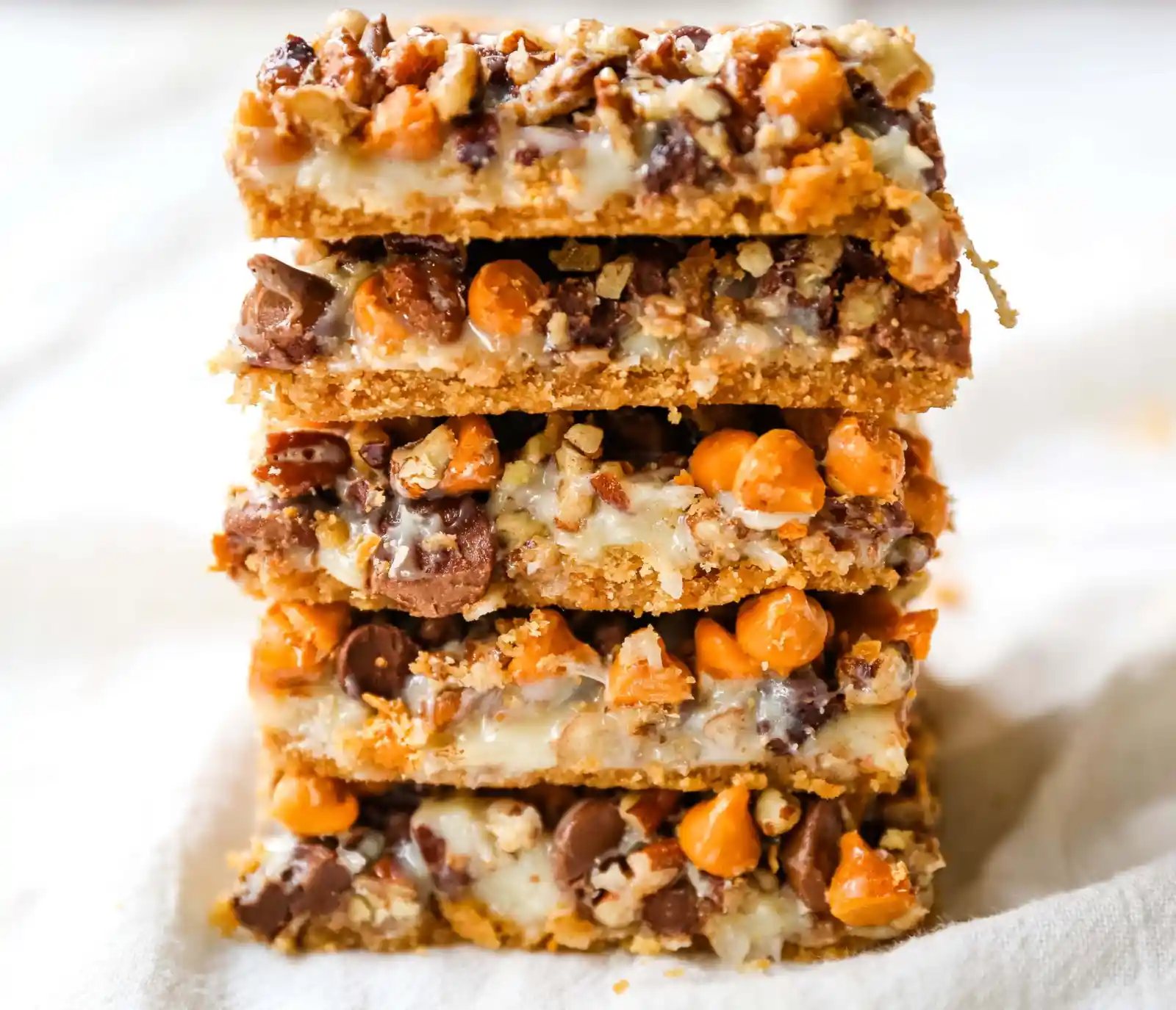7-Layer Magic Bars. The famous dessert bars made with a graham cracker crust, sweetened flaked coconut, chocolate chips, butterscotch chips, nuts, all drizzled with sweetened condensed milk. The perfect dessert bar recipe! www.modernhoney.com #7layerbars #magicbars #magiccookiebars #sevenlayerbars