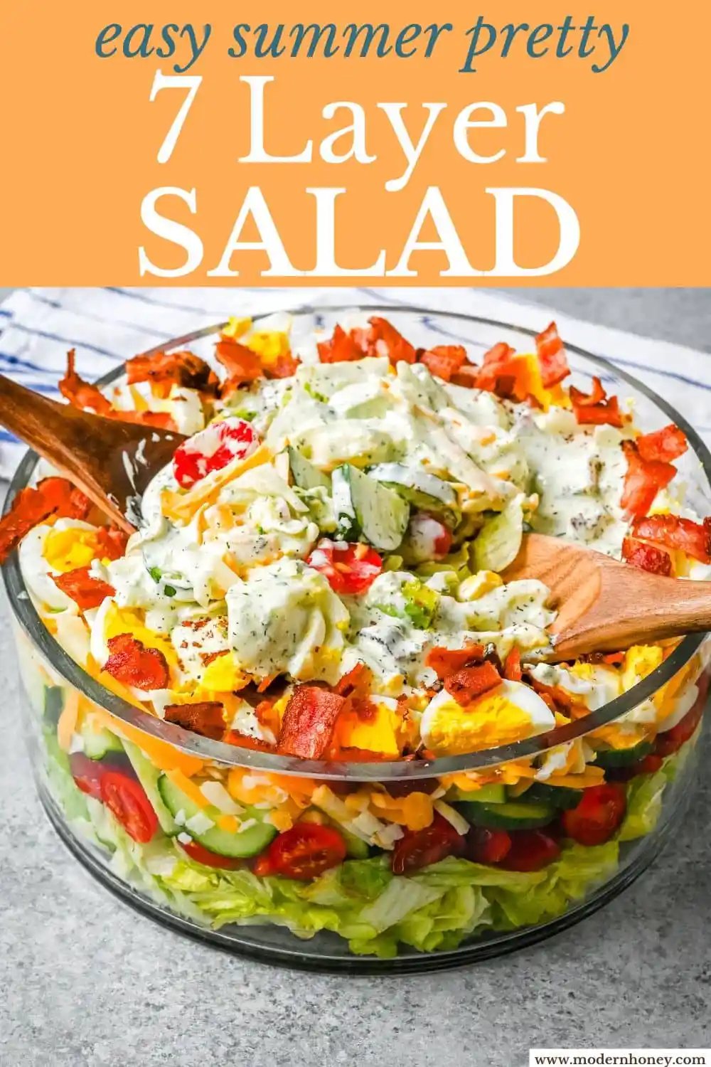 This classic Seven Layer salad is layered with iceberg lettuce, smoky bacon, hard-boiled eggs, sharp cheddar cheese, fresh veggies, and your choice of peas or garbanzo beans, plus creamy avocado. It's the ultimate make-ahead side dish, perfect for BBQs or family dinners. This easy, crowd-pleasing 7 Layer Salad is topped with a generous drizzle of homemade ranch dressing. This easy, crowd-pleasing layered salad is a beautiful, delicious side dish!