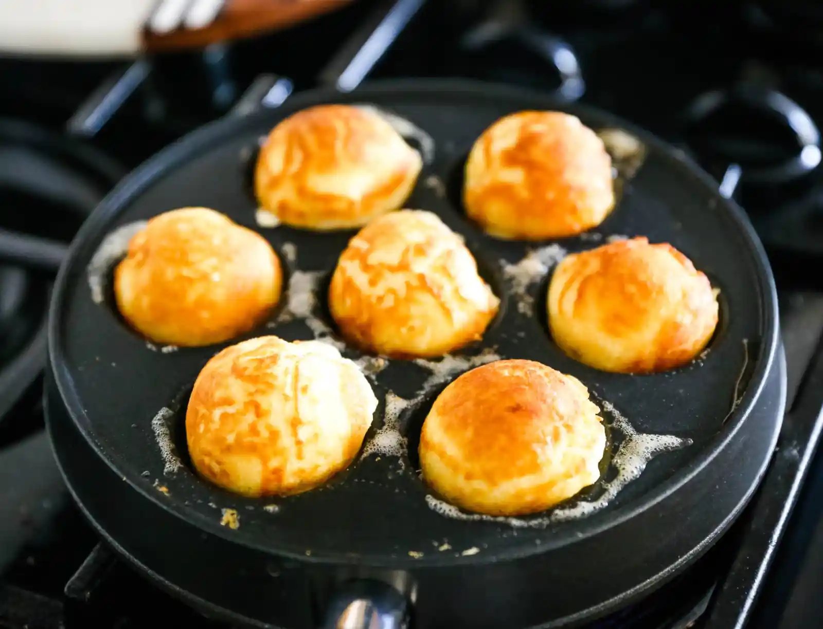 Aebleskiver Danish Pancakes a traditional Danish breakfast or dessert popular in Denmark is a circle pancake cooked in an aebleskiver pan and served with jam, powdered sugar, syrup, and fruit. www.modernhoney.com #aebleskivers #danishpancakes #pancakes