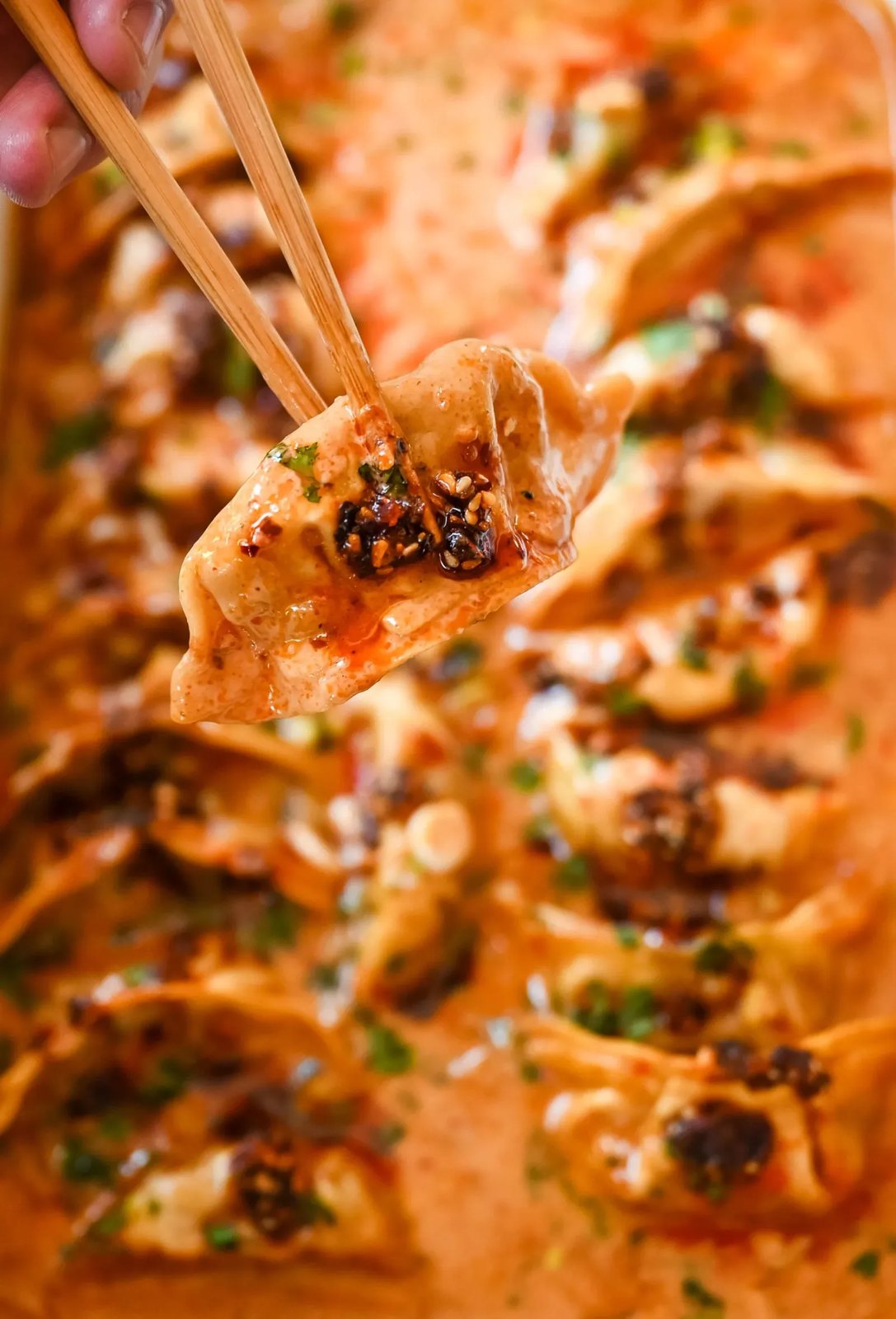 These viral baked dumplings from TikTok are the ultimate easy dinner hack! Crispy dumplings are baked in a creamy coconut curry sauce and topped with cilantro, chili crunch oil, and sesame seeds for the perfect mix of flavor and texture. This is an easy sheet pan dinner recipe!