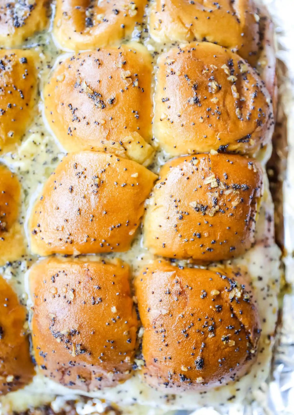 Ham and Cheese Sliders These baked ham and cheese sliders and layered with ham, melted cheese, on a Hawaiian sweet roll, and basted with a flavorful, buttery sauce. www.modernhoney.com #sandwiches #sliders #hamandcheesesliders