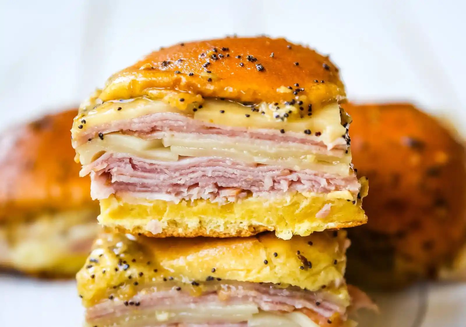 Ham and Cheese Sliders These baked ham and cheese sliders and layered with ham, melted cheese, on a Hawaiian sweet roll, and basted with a flavorful, buttery sauce. www.modernhoney.com #sandwiches #sliders #hamandcheesesliders