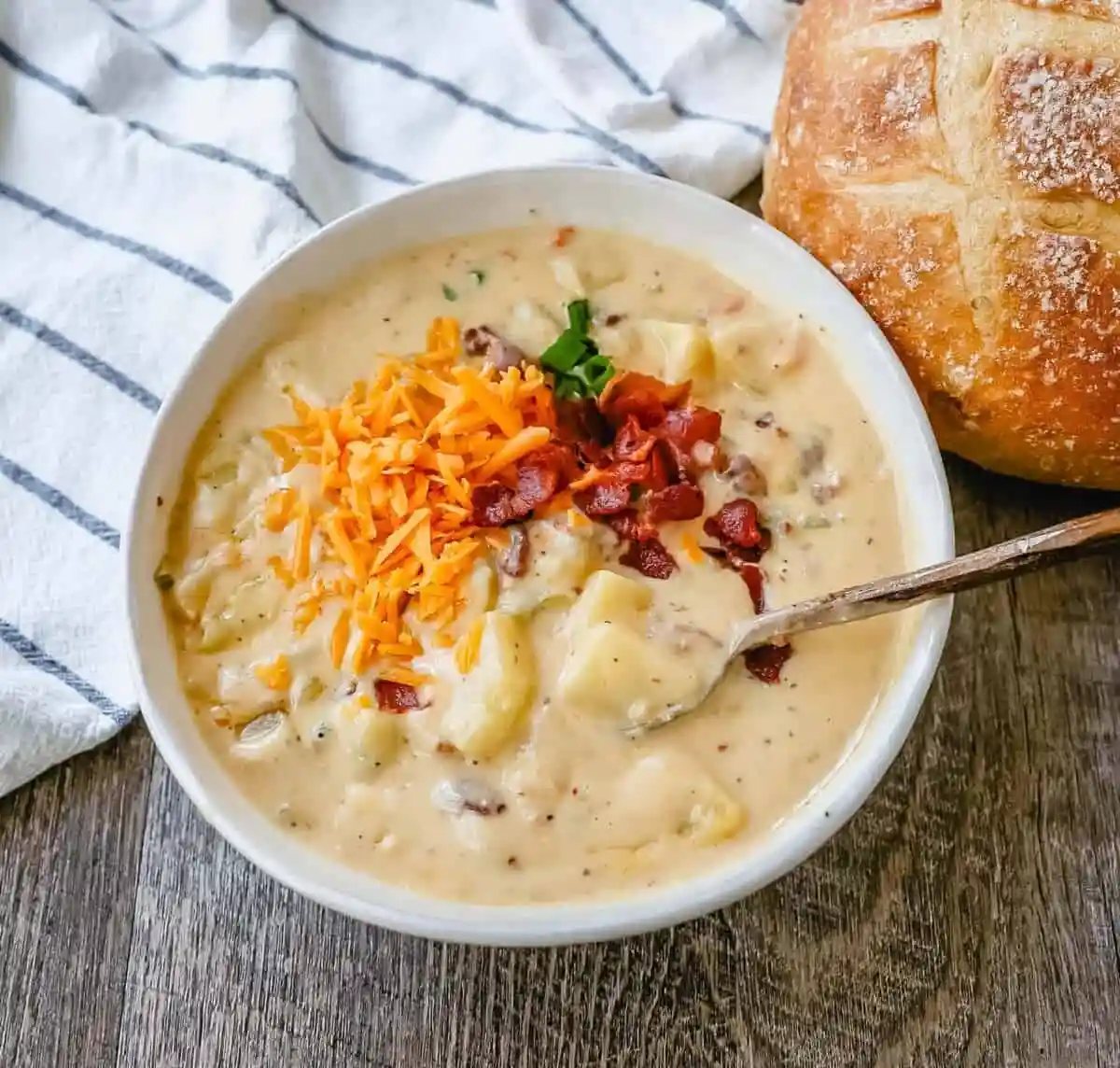 Loaded Baked Potato Soup is a rich and creamy potato cheese soup topped with crispy bacon, sour cream, green onions, and sharp cheddar cheese. A family favorite potato cheese soup recipe!