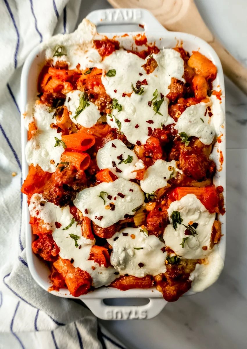 This Baked Ziti Pasta is made with ziti noodles, sausage, marinara sauce, fresh basil, spices, whole milk mozzarella cheese, parmesan cheese, and heavy cream and baked until the cheese is melted. The best-baked ziti recipe! This is a perfect recipe to freeze or make ahead of time.