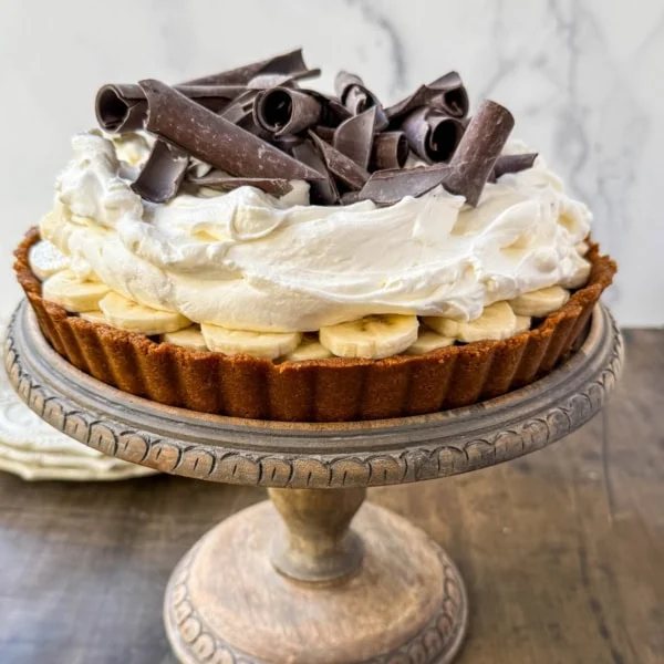 This classic banoffee pie is a no-bake dessert made with a buttery graham cracker or Biscoff cookie crust, rich toffee caramel, fresh bananas, and fluffy whipped cream. It’s a holiday dessert that delivers big flavor with no oven and minimal prep.