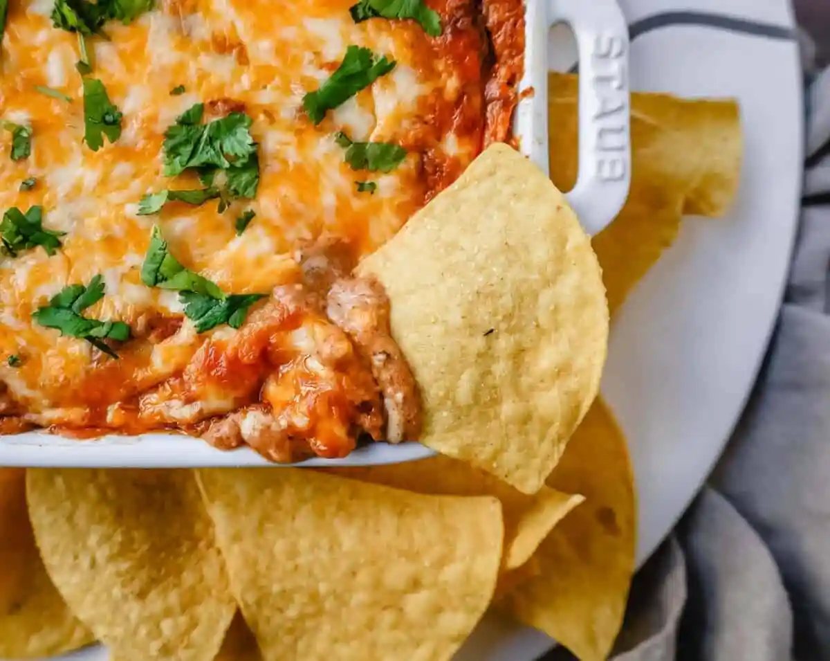 This is the best bean dip recipe ever! This is such an easy bean and cheese dip made with creamy beans, sour cream, cream cheese, taco seasoning, hot sauce, and lots of Mexican cheese! This easy bean dip is the best appetizer recipe.