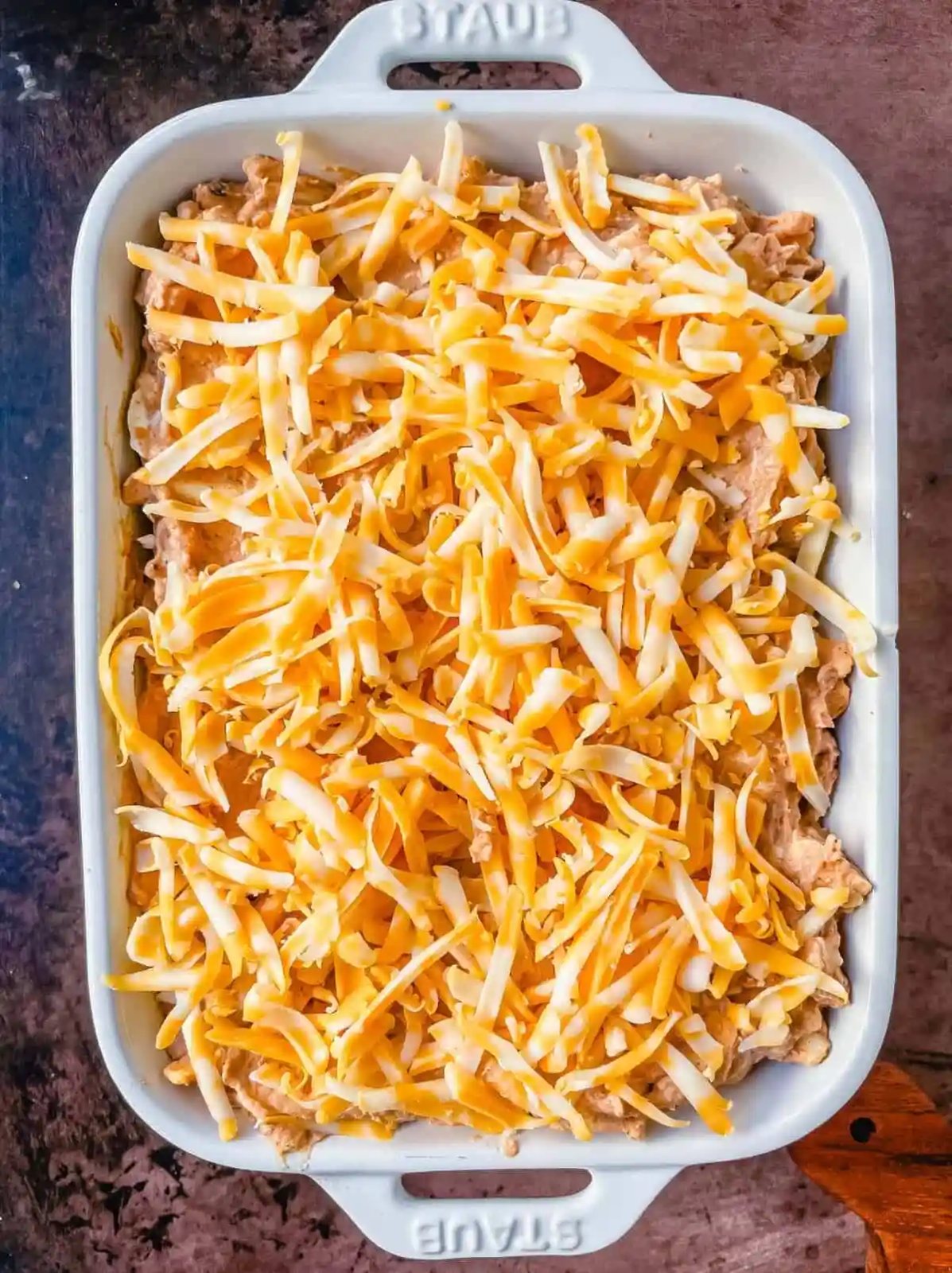 This is the best bean dip recipe ever! This is such an easy bean and cheese dip made with creamy beans, sour cream, cream cheese, taco seasoning, hot sauce, and lots of Mexican cheese! This easy bean dip is the best appetizer recipe.