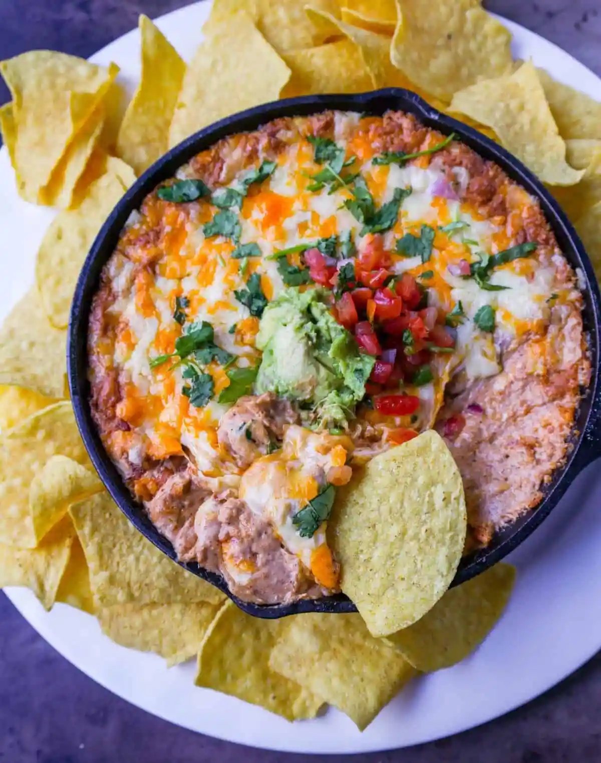 This is the best bean dip recipe ever! This is such an easy bean and cheese dip made with creamy beans, sour cream, cream cheese, taco seasoning, hot sauce, and lots of Mexican cheese! This easy bean dip is the best appetizer recipe.