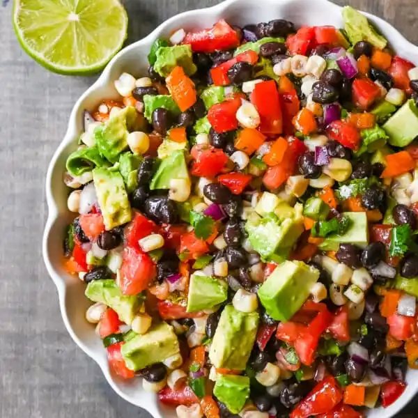 Cowboy Caviar. A popular, crowd-pleasing, fresh salsa appetizer made with black beans, corn, tomatoes, cilantro, avocado, peppers, all tossed in a zesty dressing.