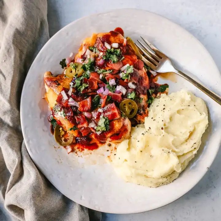 This Cowboy Chicken is Marinated Grilled Chicken topped with BBQ Sauce, Crispy Bacon, and Cheddar Cheese. Top with Fresh Cilantro and Red Onion. This is the best Monterey Chicken recipe!