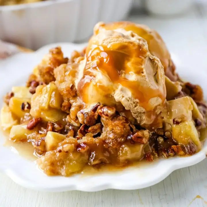 Apple Crisp. A classic Fall dessert made with sweet and tart apples and a homemade buttery brown sugar topping. This Apple Crisp recipe is made with freshly chopped sweetened apples with a handcrafted brown sugar crumble. It is a warm comforting dessert topped with vanilla bean ice cream and salted caramel. www.modernhoney.com #applecrisp #appledesserts #appledessert #dessert