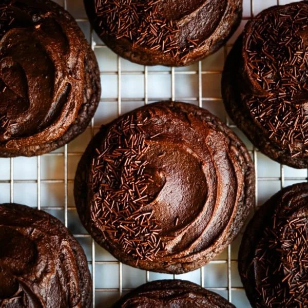 These easy Chocolate Frosted Cookies combine soft chocolate cookies with a rich, chocolate buttercream frosting. The double chocolate cookie base is filled with melty chocolate chips and a smooth cocoa frosting on top. These Frosted Chocolate Cookies are a chocolate lover’s dream.