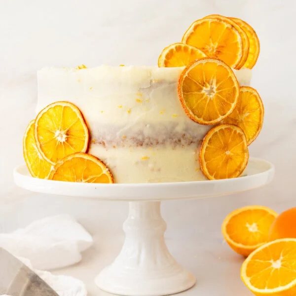 A moist, tender fresh orange cake with a sweet orange cream cheese frosting. This homemade orange cake that is bursting with bright citrus flavor in every bite. Each layer is moist, fluffy, and perfectly enhanced by an orange cream cheese frosting. The fresh orange juice and zest adds fresh orange flavor. Here are tips for making the perfect frosted orange cake! This can also be made into an orange naked cake.