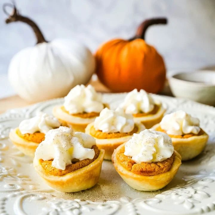 Mini Pumpkin Pie Bites. The best bite-size mini pumpkin pies perfect for entertaining during the holiday season. Creamy pumpkin pie filling in buttery pie crust cups topped with fresh whipped cream. www.modernhoney.com #pumpkinpie #pumpkinpiebites #minipumpkinpies