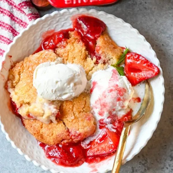 This warm, bubbling strawberry cobbler is everything summer should taste like...sweet, juicy berries tucked under a golden, buttery crust. Top it with vanilla ice cream and watch it disappear.