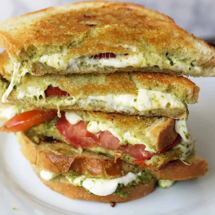 Pesto Panini with Fresh Mozzarella and Tomato. A toasted buttery panini with basil pesto, melted fresh mozzarella cheese, and juicy tomatoes. www.modernhoney.com #panini #sandwich #pesto #grilledsandwich
