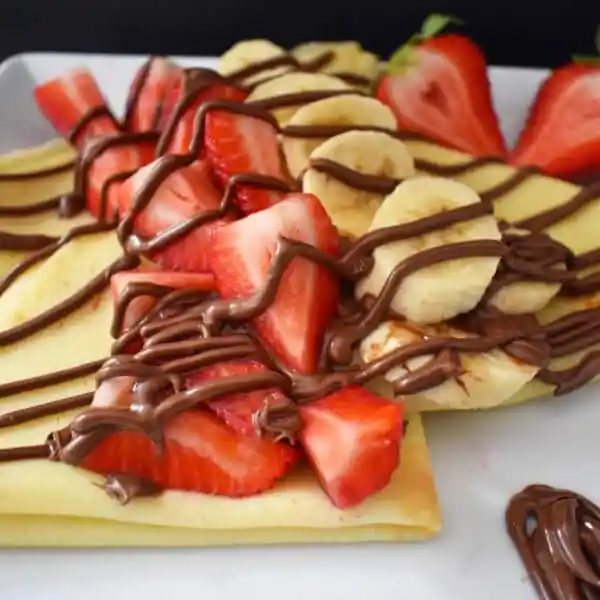 Perfect Crepe Recipe with Nutella and Strawberries. Buttery French crepes that melt-in-your-mouth. A list of crepe topping ideas and where to buy the best crepe pans. www.modernhoney.com