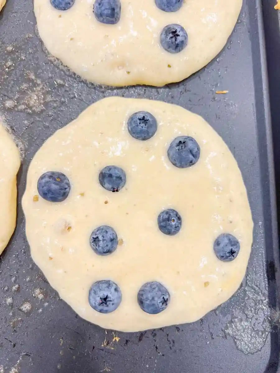 Homemade fluffy blueberry pancakes are made with fresh blueberries and are the best buttermilk blueberry pancakes ever! These are easy blueberry pancakes made from scratch.