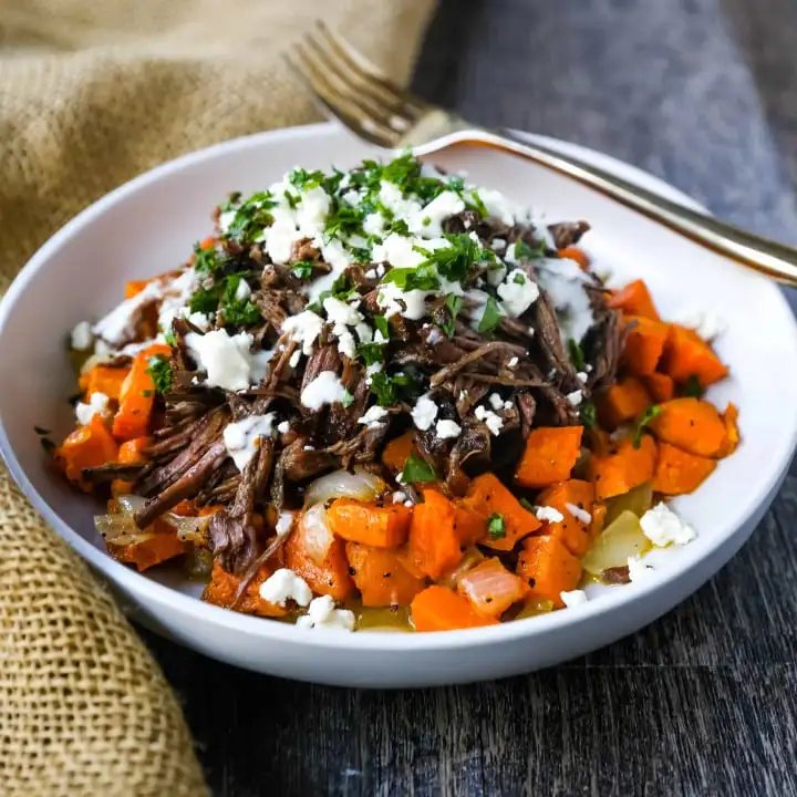Braised Beef and Sweet Potato Hash Bowl. Tender braised beef on top of a sweet potato onion hash and topped with feta cheese and herbs. www.modernhoney.com #bowl #bowls #dinner