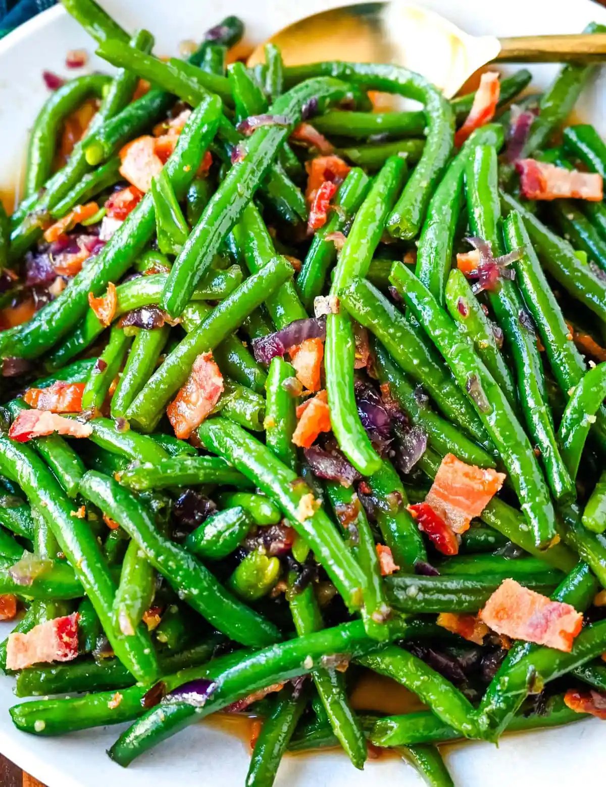This recipe for brown sugar bacon green beans brings a sweet and savory twist to traditional green beans with the addition of crispy bacon, caramelized onions, and a buttery brown sugar glaze. This easy side dish is perfect for holiday dinners, Thanksgiving or as crowd pleasing side dish, adding just the right amount of richness to fresh green beans while keeping them fresh and crisp-tender.