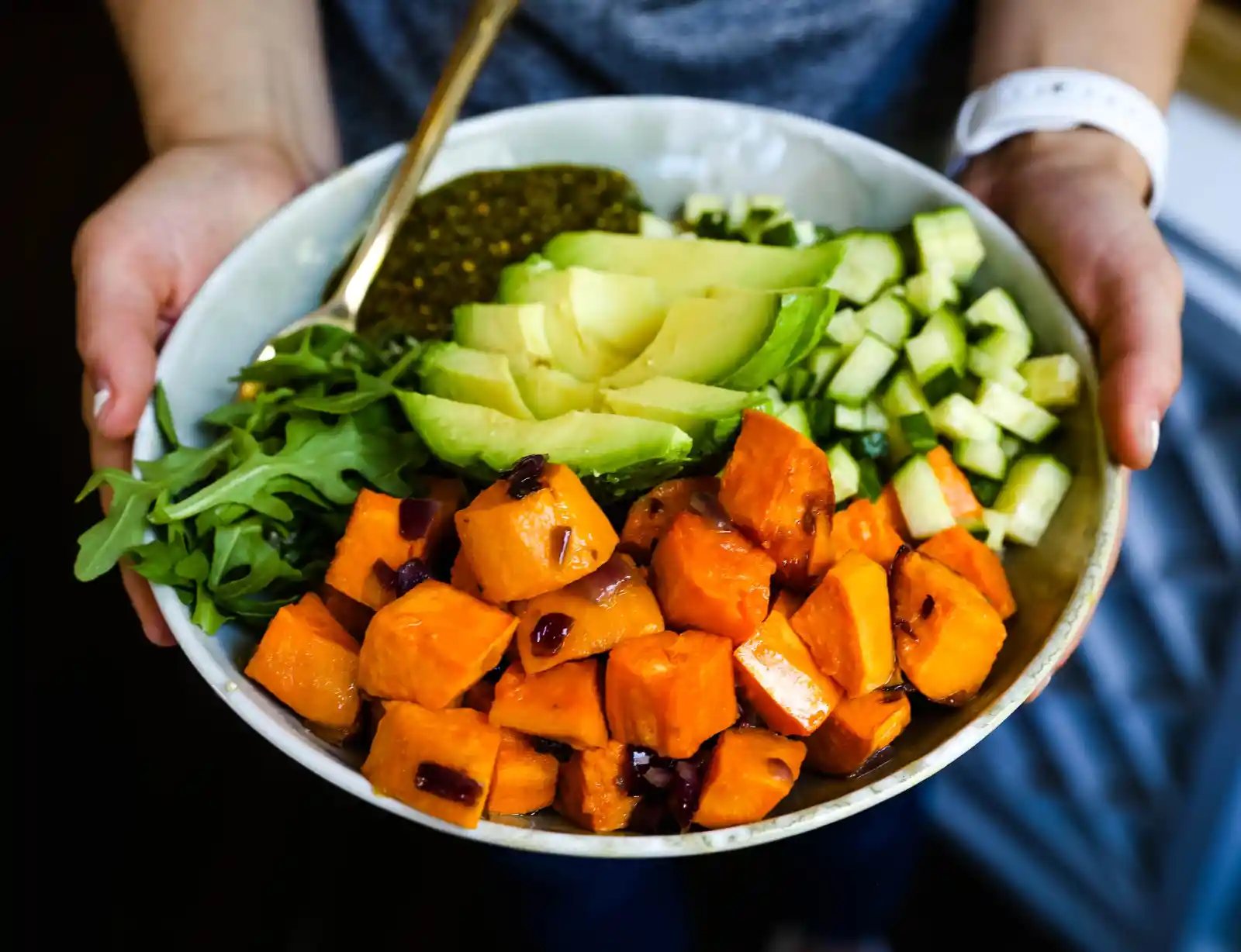 Buddha Bowl with Pistachio Pesto A healthy vegan bowl made with roasted sweet potatoes, onions, fresh avocado, cucumbers, arugula, quinoa, and homemade pistachio pesto. www.modernhoney.com #buddhabowl #vegan #vegetarian #flowerchild