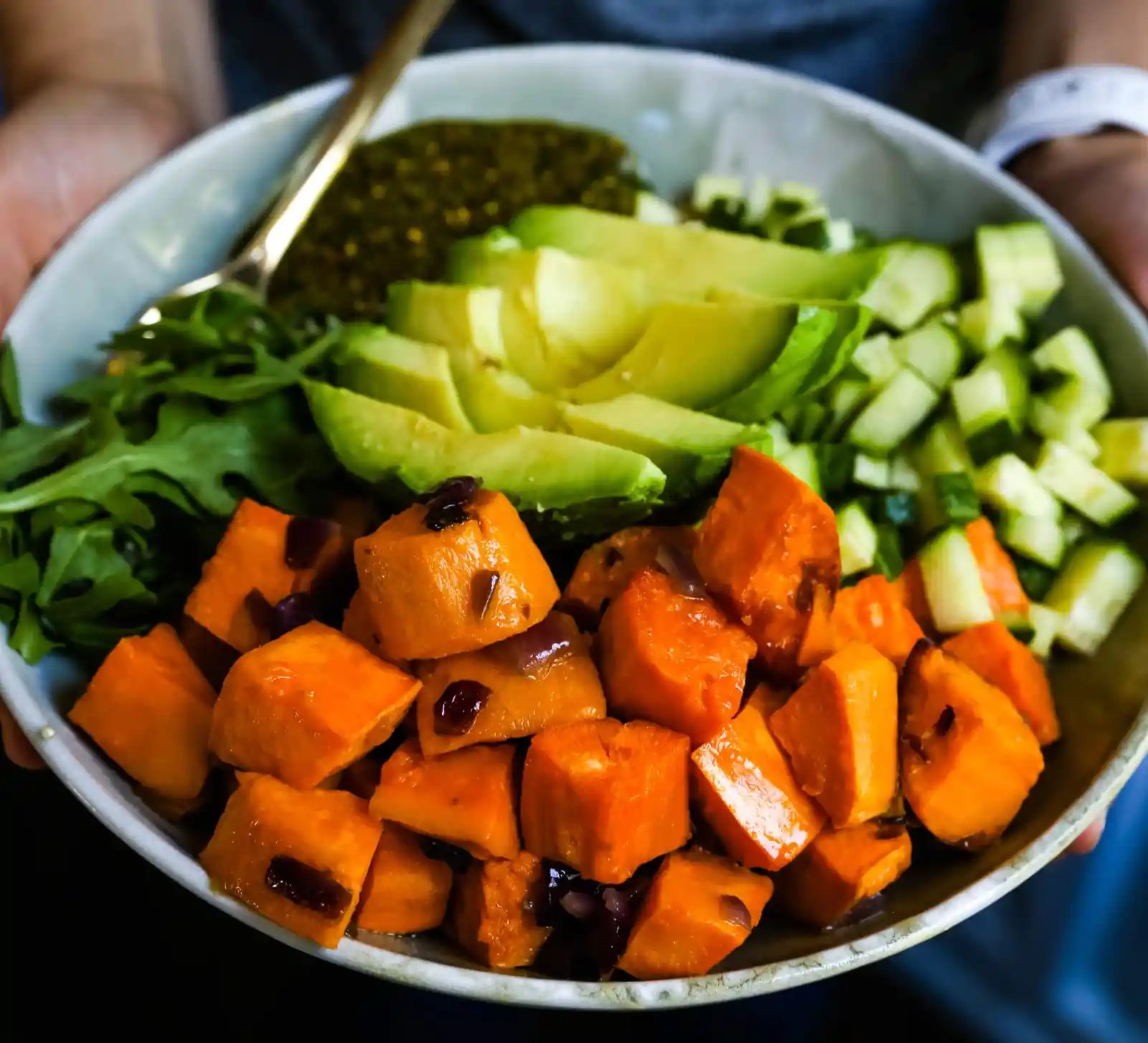 Buddha Bowl with Pistachio Pesto A healthy vegan bowl made with roasted sweet potatoes, onions, fresh avocado, cucumbers, arugula, quinoa, and homemade pistachio pesto. www.modernhoney.com #buddhabowl #vegan #vegetarian #flowerchild