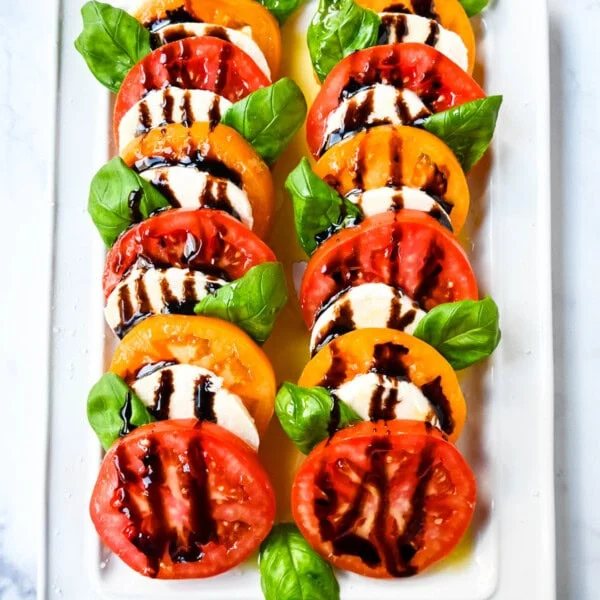 This caprese salad is the ultimate fresh summer dish, made with juicy, colorful heirloom tomatoes, creamy mozzarella, balsamic glaze and fragrant basil. If you’re looking for a fresh tomato salad recipe that’s both beautiful and delicious, this is it.