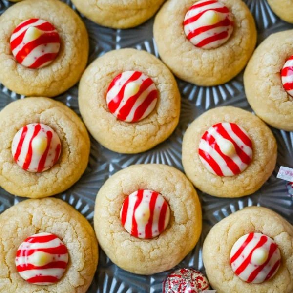 These Candy Cane Kiss Cookies are soft, buttery sugar cookies rolled in sparkling sugar or festive sprinkles, baked until just set, and then pressed with a striped peppermint Candy Cane Kiss right in the center. This Peppermint Kiss Cookie is such a festive Christmas cookie recipe.