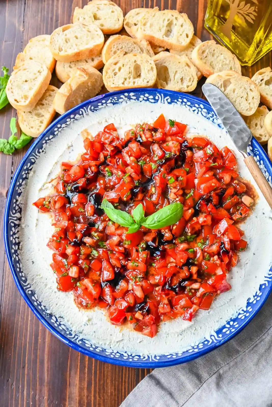 This quick and easy appetizer is made with garlic and herb Boursin cheese and topped with a fresh caprese salad made with tomatoes, olive oil, balsamic glaze, basil, and garlic. This Caprese Dip with boursin cheese pairs perfectly with crostinis or crackers.