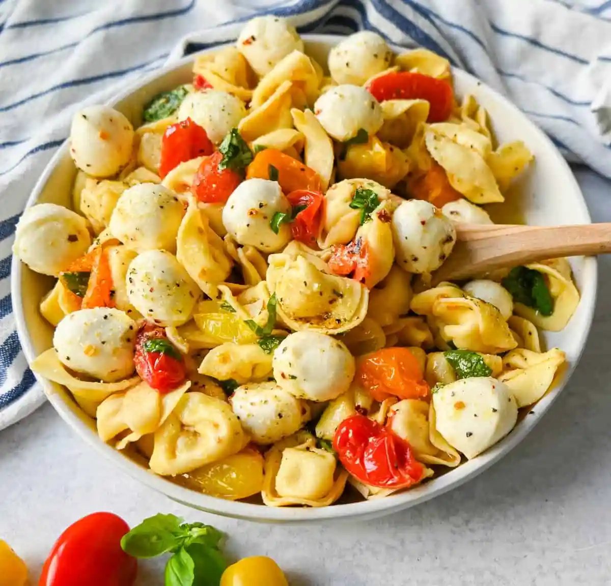 This Caprese Tortellini is made with cheese Tortellini tossed with sauteed garlic and tomatoes in extra virgin olive oil, fresh basil, and fresh mozzarella and spices. This fresh tortellini caprese pasta is perfect for summer!