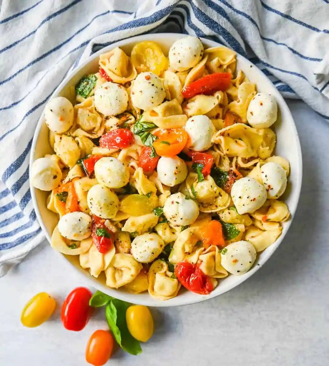 This Caprese Tortellini is made with cheese Tortellini tossed with sauteed garlic and tomatoes in extra virgin olive oil, fresh basil, and fresh mozzarella and spices. This fresh tortellini caprese pasta is perfect for summer!