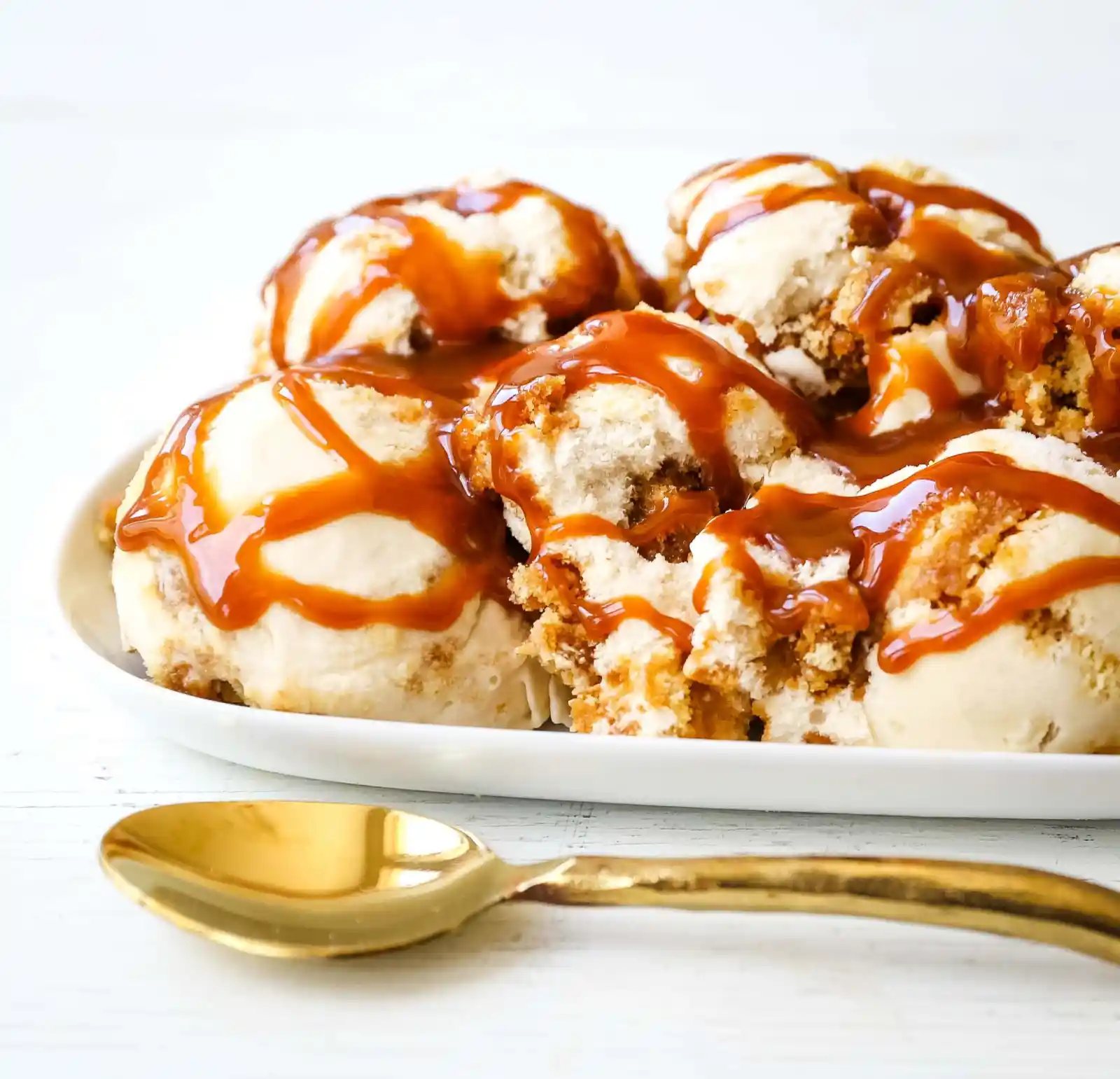 Caramel Gooey Butter Cake Ice Cream. Creamy homemade vanilla ice cream with chunks of homemade butter cake and swirls of decadent sweet caramel. www.modernhoney.com #icecream #homemadeicecream #caramel