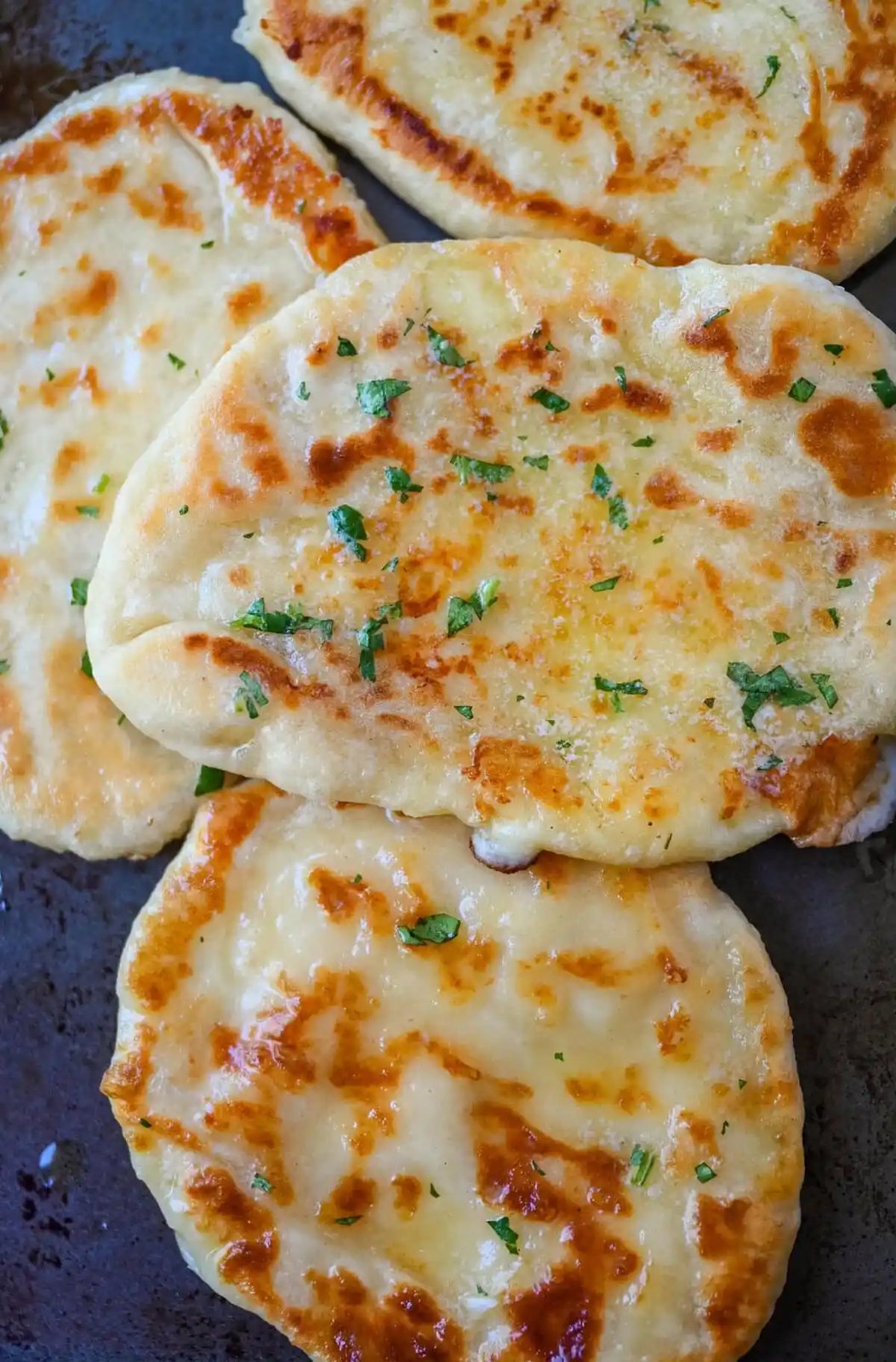 Homemade Cheesy Naan bread stuffed with mozzarella cheese, that is even better than what you find in restaurants. Cheese-stuffed naan is soft, slightly chewy, golden-brown on the outside, fluffy bread layers inside, and melty gooey cheese in the center.