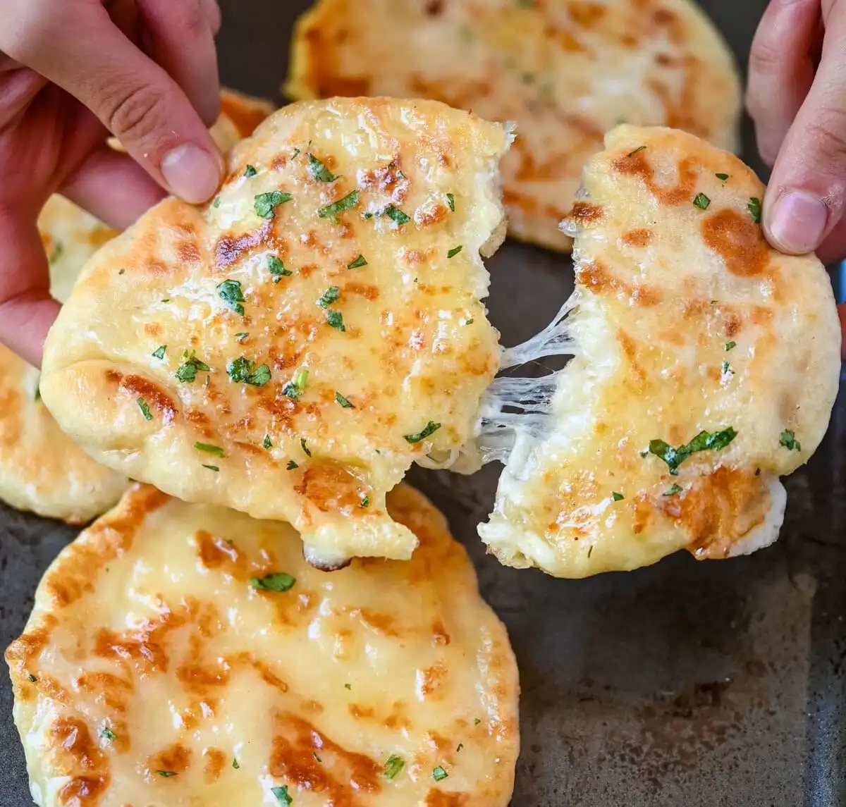 Homemade Cheesy Naan bread stuffed with mozzarella cheese, that is even better than what you find in restaurants. Cheese-stuffed naan is soft, slightly chewy, golden-brown on the outside, fluffy bread layers inside, and melty gooey cheese in the center.
