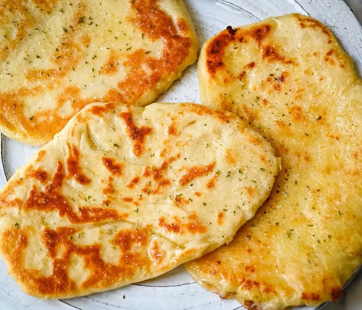 Homemade Cheesy Naan bread stuffed with mozzarella cheese, that is even better than what you find in restaurants. Cheese-stuffed naan is soft, slightly chewy, golden-brown on the outside, fluffy bread layers inside, and melty gooey cheese in the center.