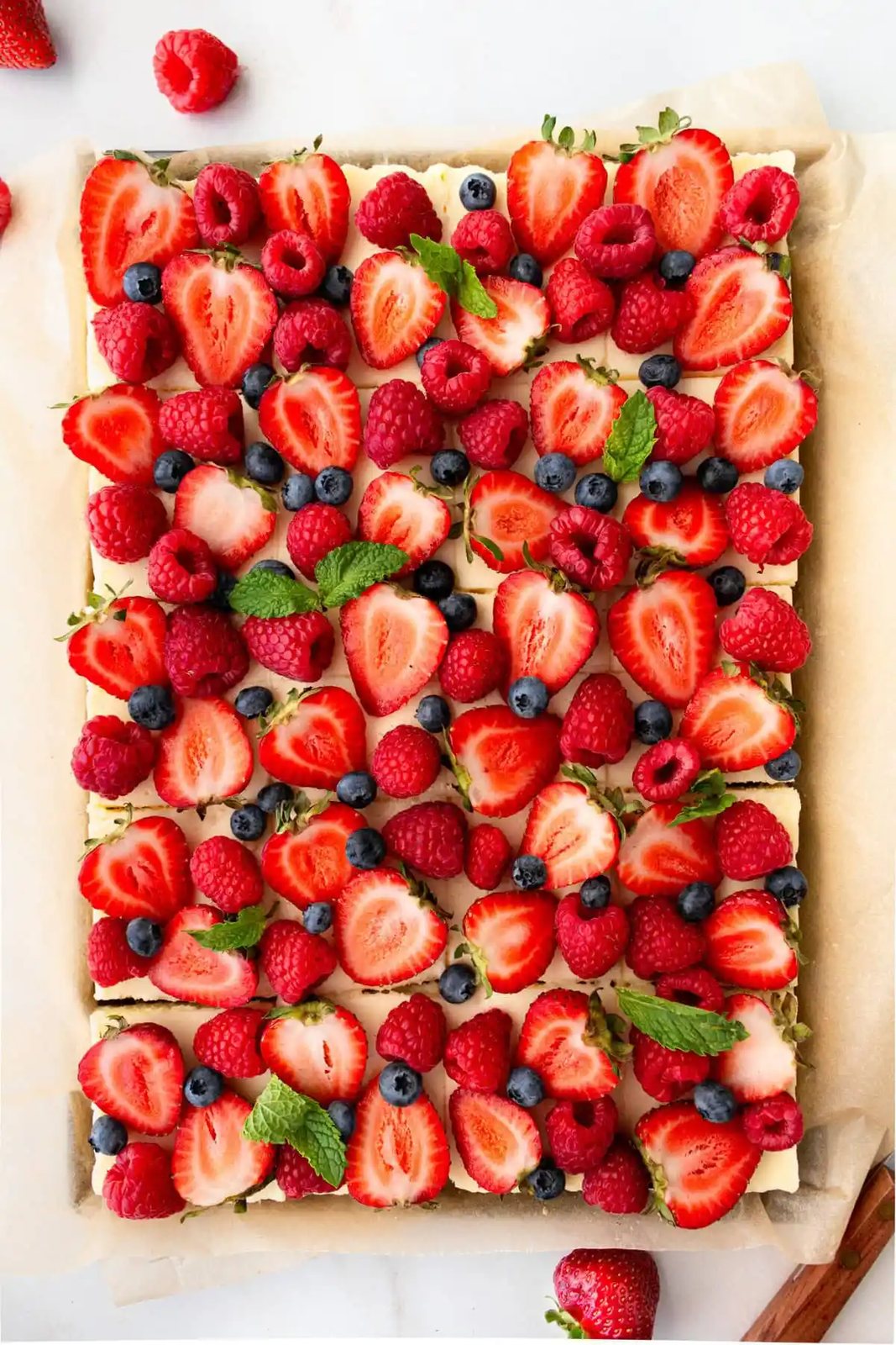 Creamy luscious cheesecake bars with a buttery graham cracker crust and topped with fresh berries is a crowd-pleasing popular dessert! They feature a creamy, tangy cheesecake filling atop a buttery graham cracker crust, baked to perfection in a bar form. Whether you're looking for a treat for a party, a family dessert, or simply craving cheesecake, these cheesecake bars are a hit.