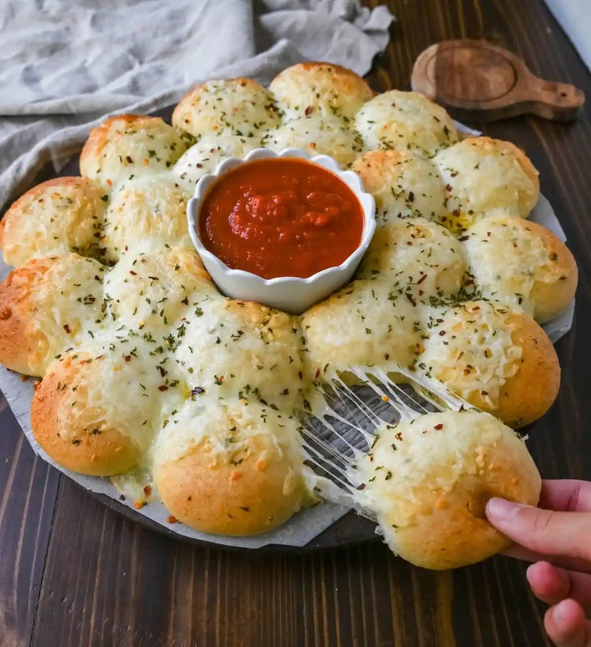 Cheesy garlic monkey bread, or garlic cheese pull-apart bread, made with Rhodes frozen dinner rolls, is soft, buttery, and cheesy. Each roll is dipped in garlic butter and then topped with gooey, melted mozzarella cheese that bubbles as it bakes. The result is a pull-apart bread that's golden on the outside, fluffy on the inside, and has cheesy, garlicky goodness in every bite.