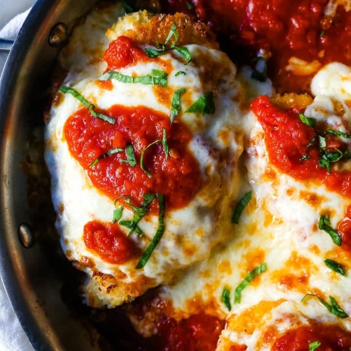 Chicken Parmesan. Panko-crusted chicken breast topped with homemade marinara sauce, melted whole milk mozzarella, and parmesan cheeses and baked until golden and bubbly. www.modernhoney.com #chicken #chickenparmesan #italian