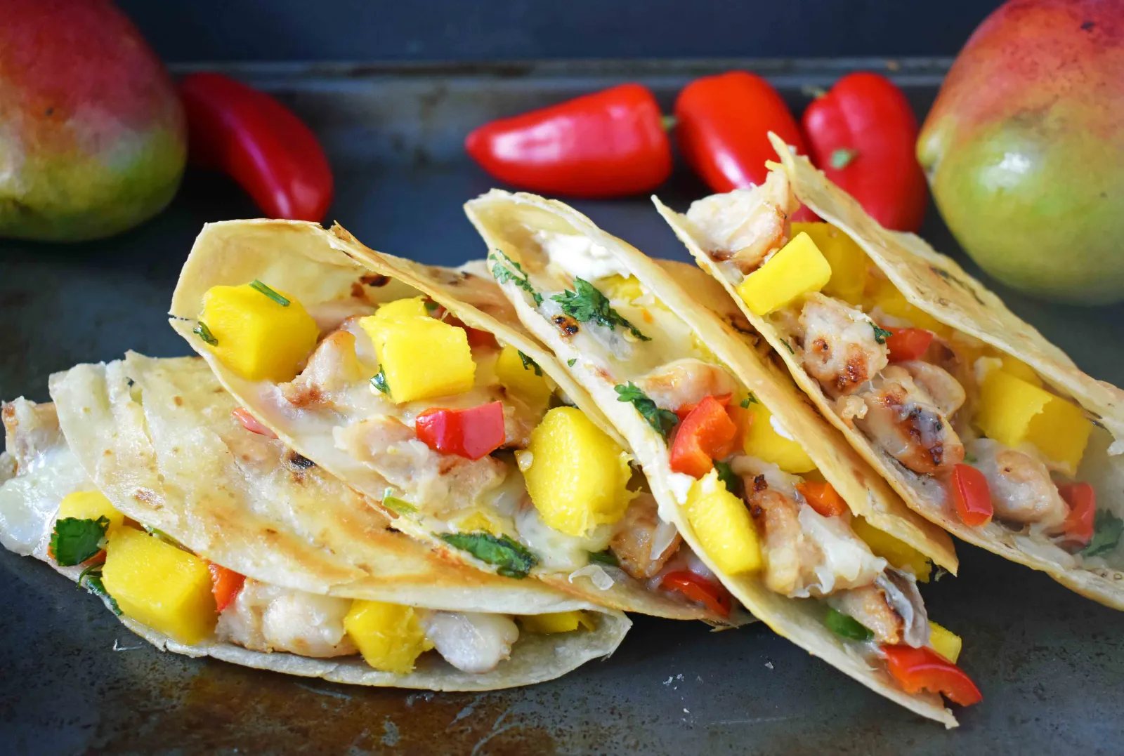 Chicken Mango Quesadillas made with honey lime chicken, homemade fresh mango salsa, pepper jack cheese, and an optional jalapeno cream cheese all melted inside a buttery tortilla. A popular Mexican dinner made in less than 30 minutes. www.modernhoney.com