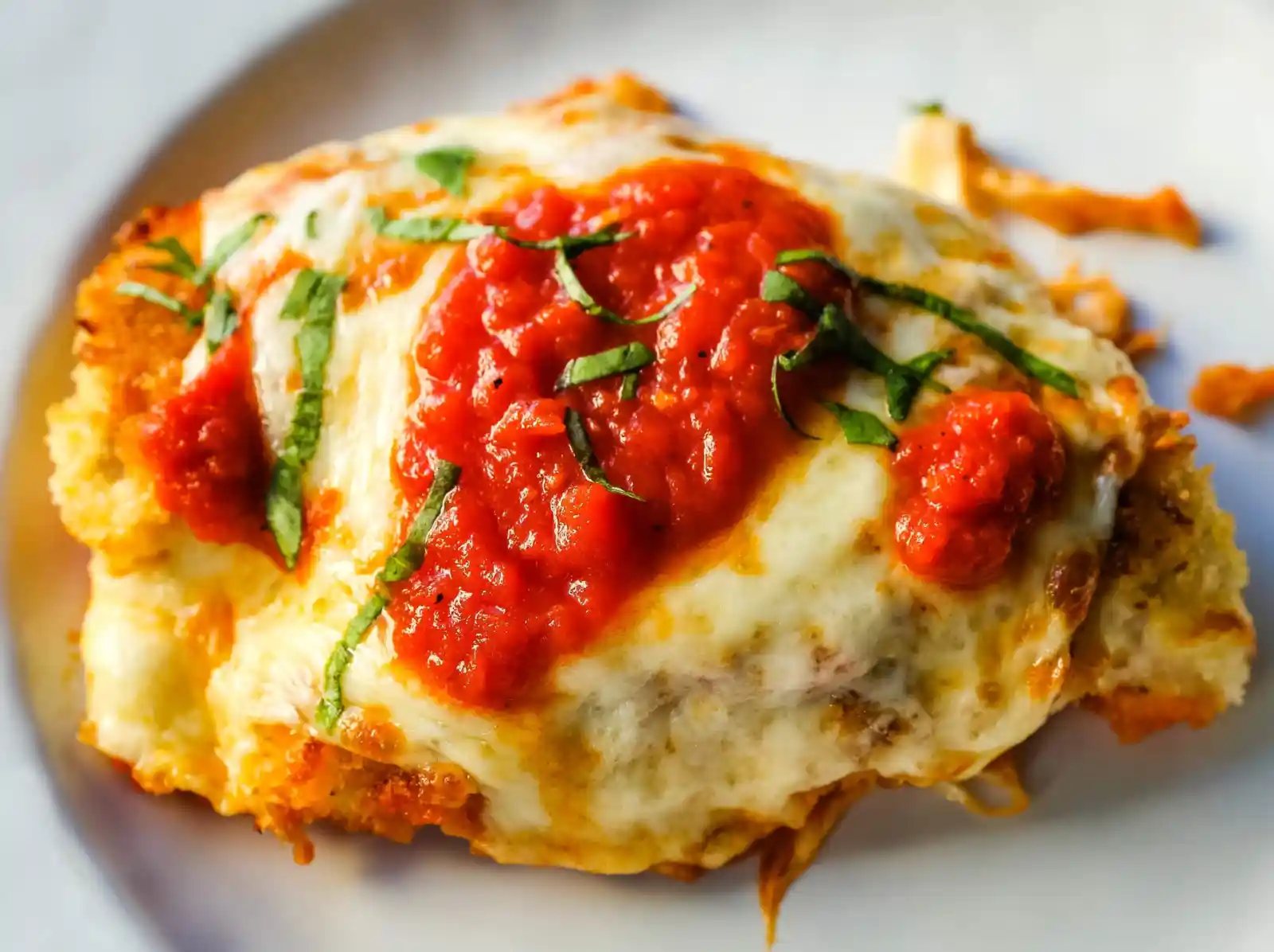 Chicken Parmesan. Panko-crusted chicken breast topped with homemade marinara sauce, melted whole milk mozzarella, and parmesan cheeses and baked until golden and bubbly. www.modernhoney.com #chicken #chickenparmesan #italian
