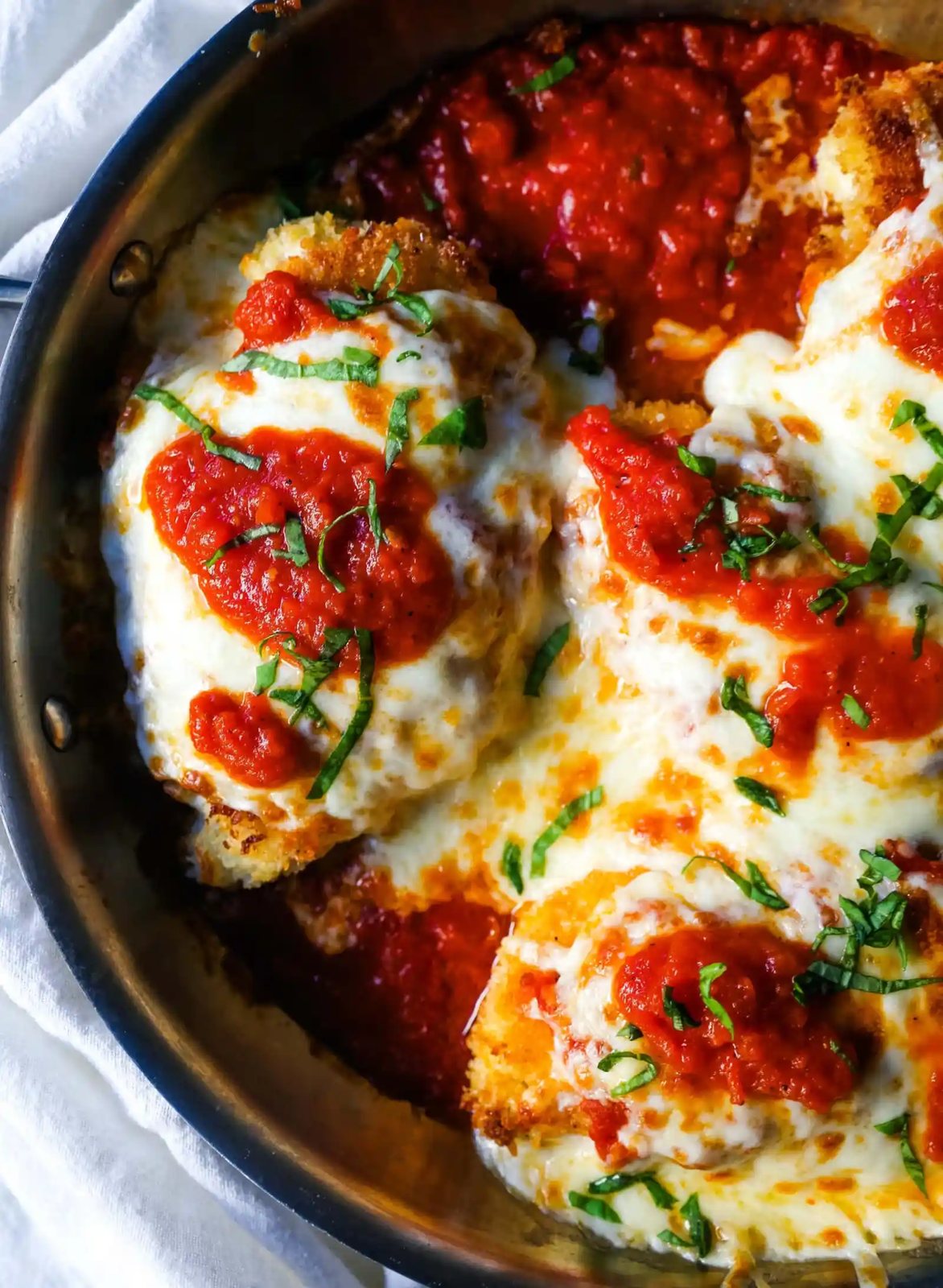 Chicken Parmesan. Panko-crusted chicken breast topped with homemade marinara sauce, melted whole milk mozzarella, and parmesan cheeses and baked until golden and bubbly. www.modernhoney.com #chicken #chickenparmesan #italian