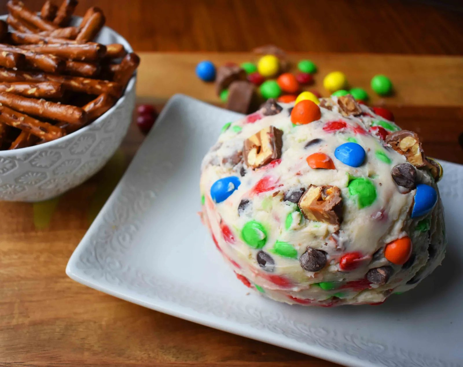 Chocolate Candy Bar Cheese Ball by Modern Honey. A popular sweet cheese ball that is perfect for parties. Dip pretzels in sweet candy bar dip.