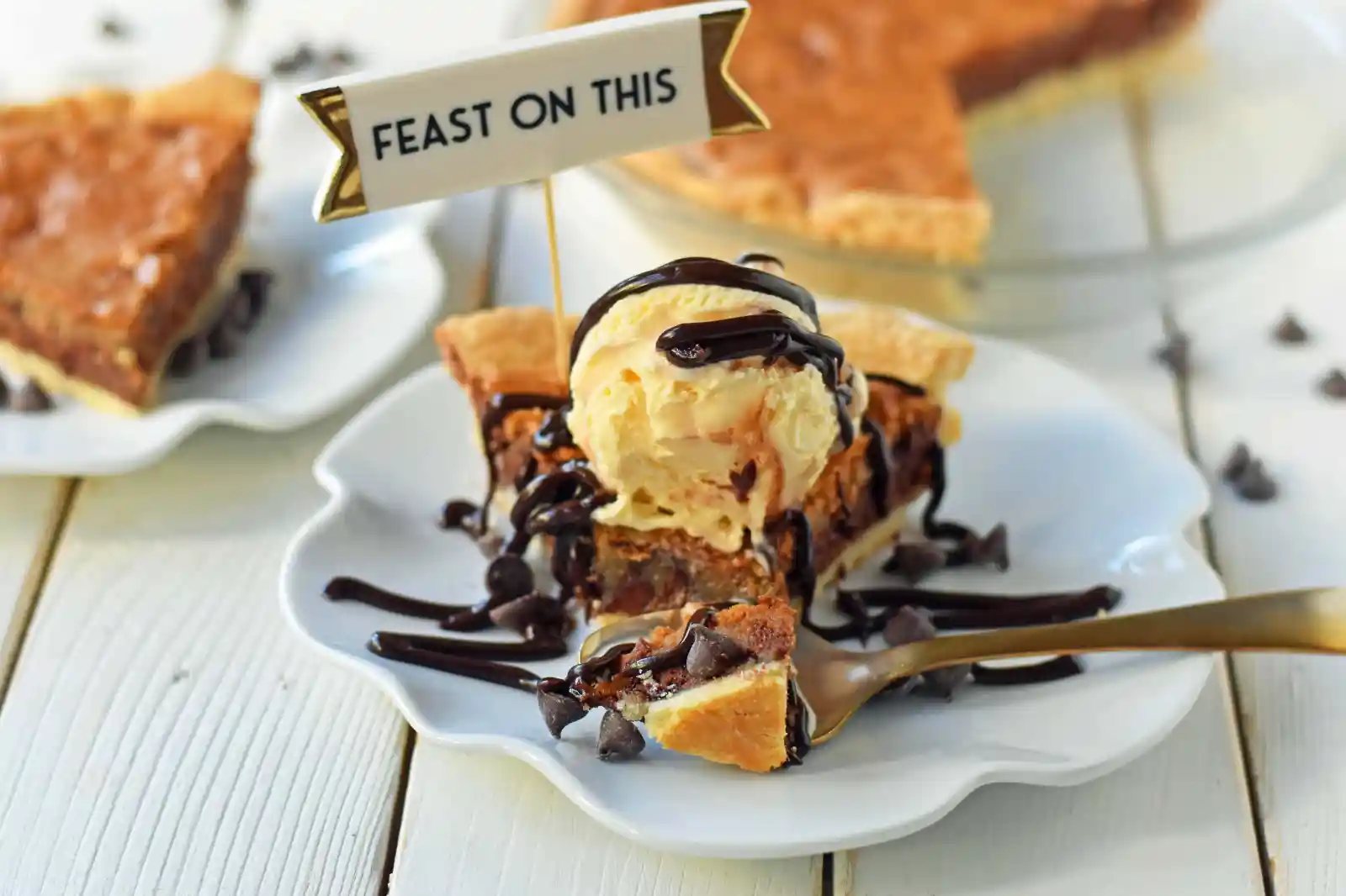 Chocolate Chip Cookie Pie with homemade chocolate chip cookie dough baked in a buttery flaky pie crust and topped with vanilla bean ice cream and hot fudge. The BEST Chocolate Chip Cookie Pie Recipe. www.modernhoney.com