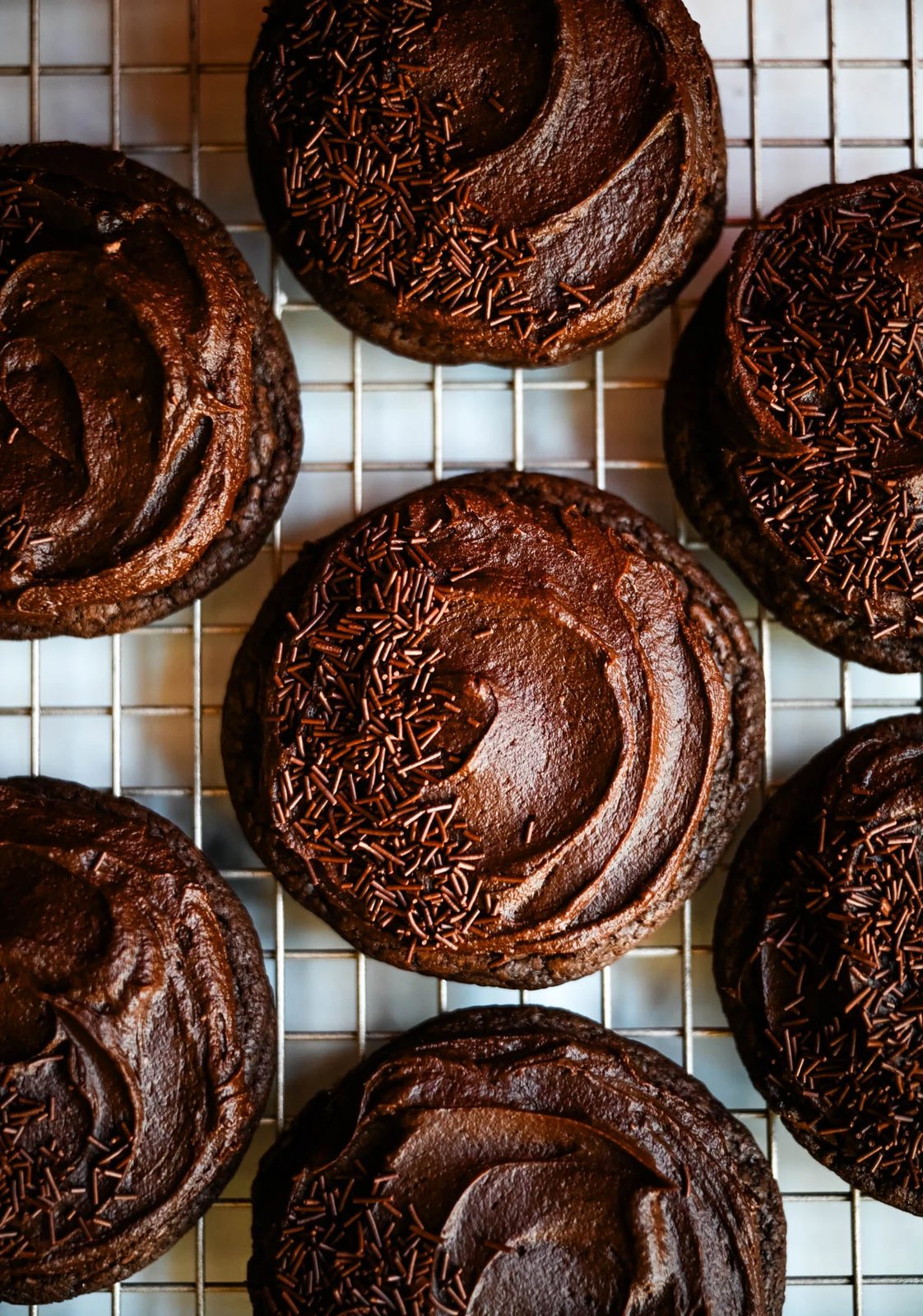 These easy Chocolate Frosted Cookies combine soft chocolate cookies with a rich, chocolate buttercream frosting. The double chocolate cookie base is filled with melty chocolate chips and a smooth cocoa frosting on top. These Frosted Chocolate Cookies are a chocolate lover’s dream.
