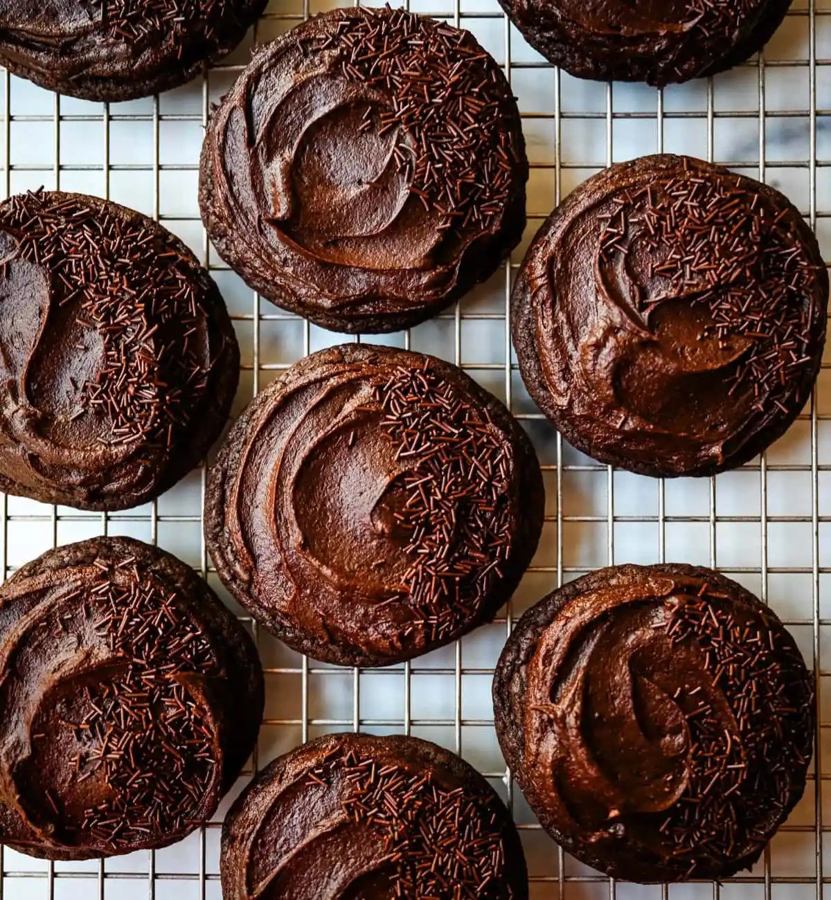 These easy Chocolate Frosted Cookies combine soft chocolate cookies with a rich, chocolate buttercream frosting. The double chocolate cookie base is filled with melty chocolate chips and a smooth cocoa frosting on top. These Frosted Chocolate Cookies are a chocolate lover’s dream.
